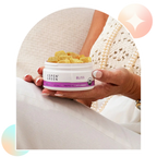 Hand holding a container of Aspen Green Bliss CBD Gummies with a blurred background.