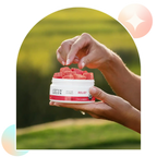Woman taking an Aspen Green Relief CBD gummy from an open jar with a blurred outdoor background.