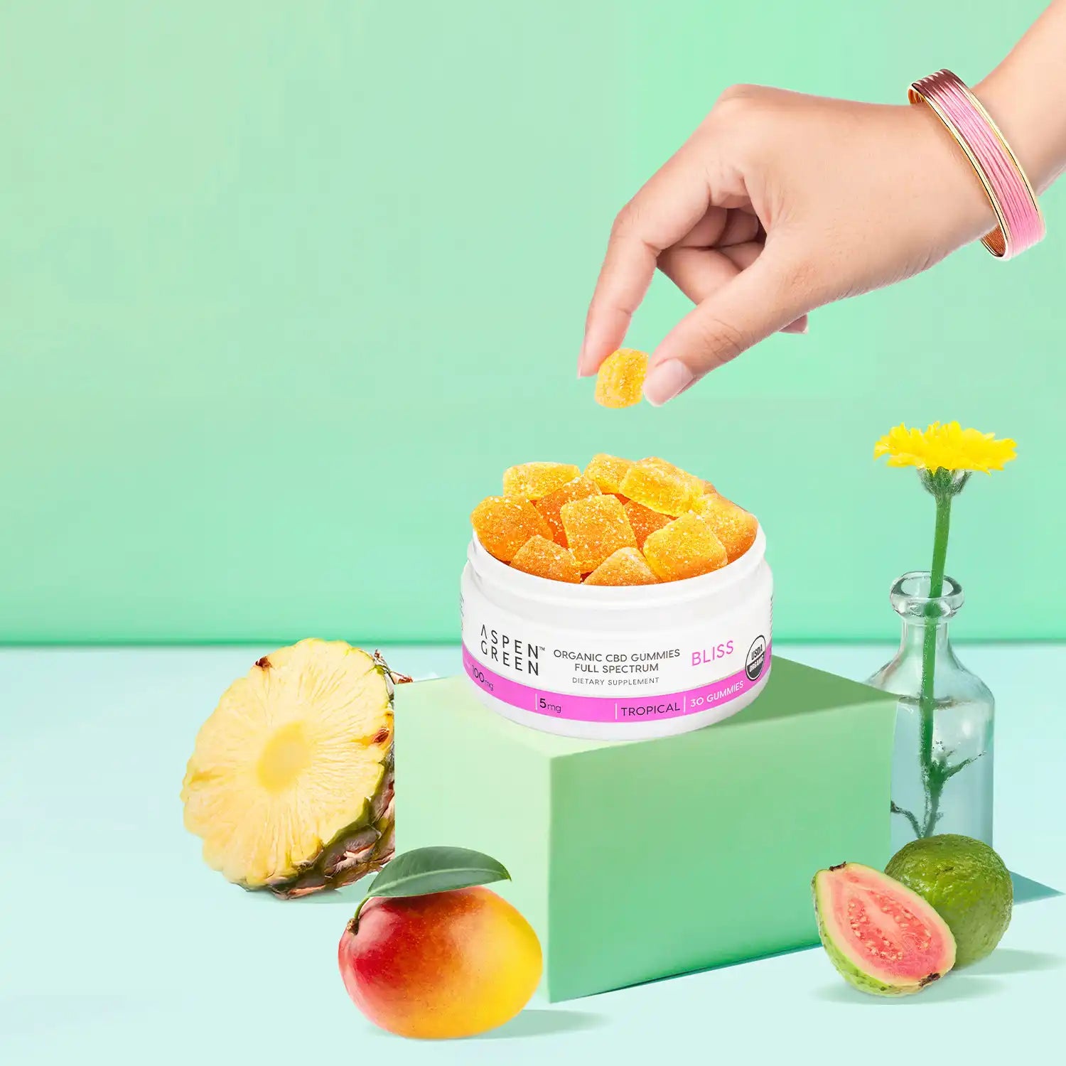 Woman’s hand picking Aspen Green CBD Bliss Gummies from an open container